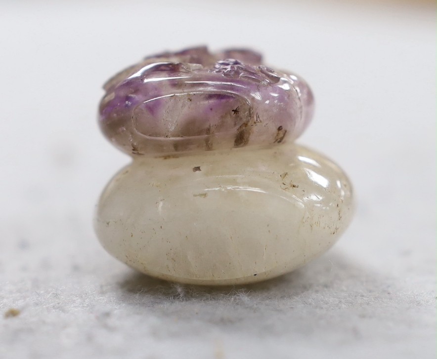 A 19th century Chinese quartz double snuff bottle, 6cm, the carver skilfully incorporating the amethyst crystal inclusions to the relief carving of the front bottle